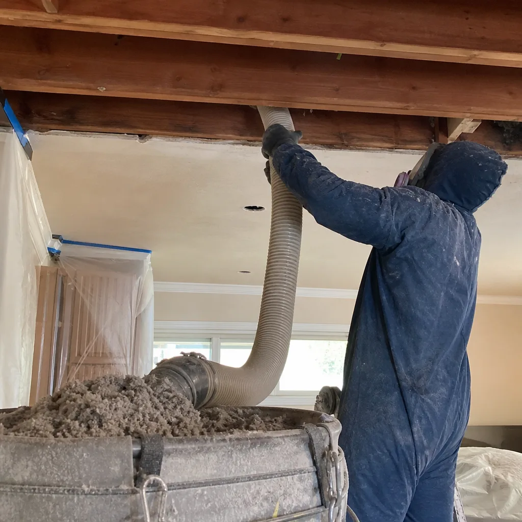 Technician using industrial hose for blown-in attic insulation installation